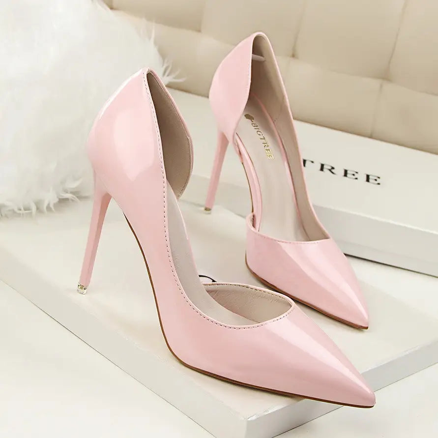 Pink patent leather high-heeled pumps with a pointed toe and slender stiletto heel designed for elegant wear.