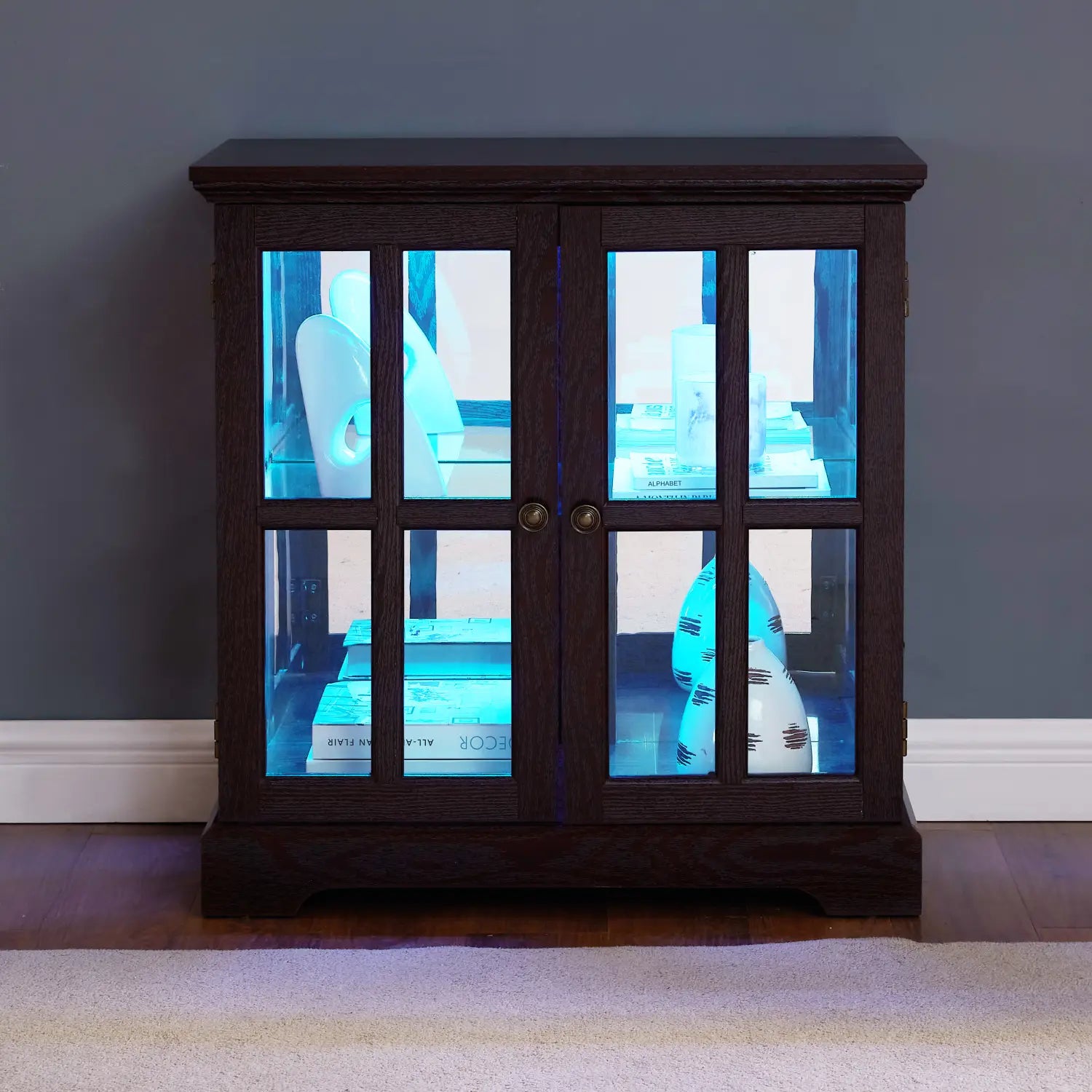 Led curio display cabinet made of dark wood featuring glass doors and blue interior lighting with adjustable shelves.