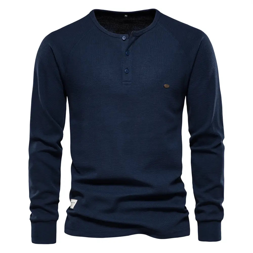 Chemise henley à manches longues côtelée pour homme, en bleu marine, avec un col à trois boutons et un tissu texturé.