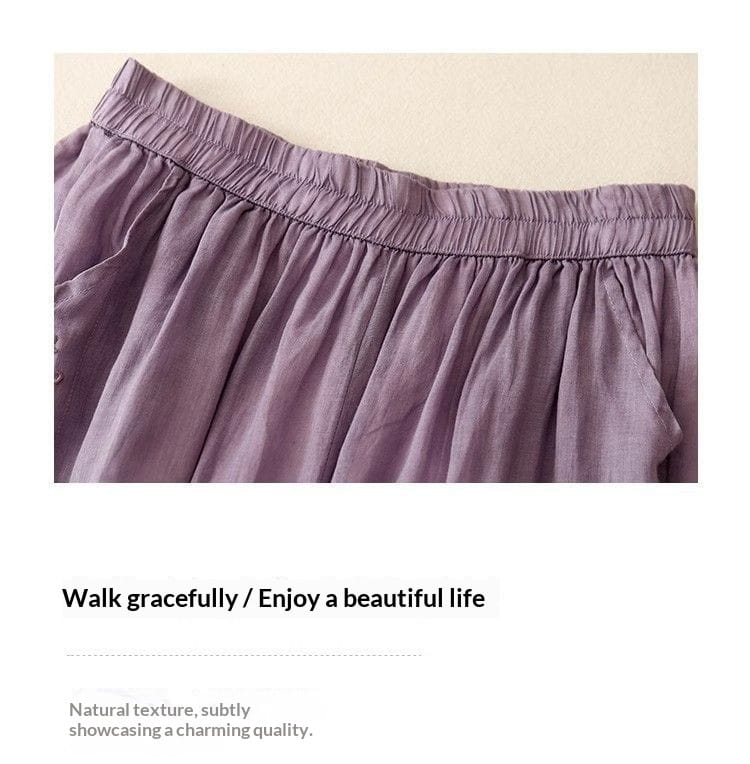Eine weich lavendelfarbene bestickte Baumwoll-Leinen-Wide-Leg-Hose mit gerafftem elastischem Bund und einem fließenden Stoffdesign.