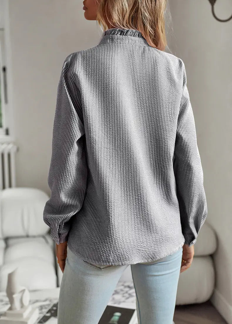 Gray ribbed cotton ruffle trim textured long sleeve button up blouse with a subtle striped pattern and a classic collar.