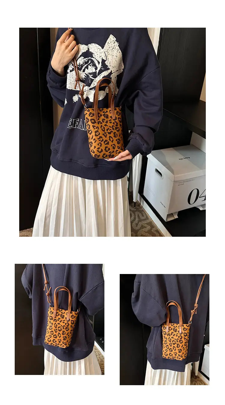 A small tan leopard print suede mini bucket crossbody bag with brown leather handles and an adjustable strap.