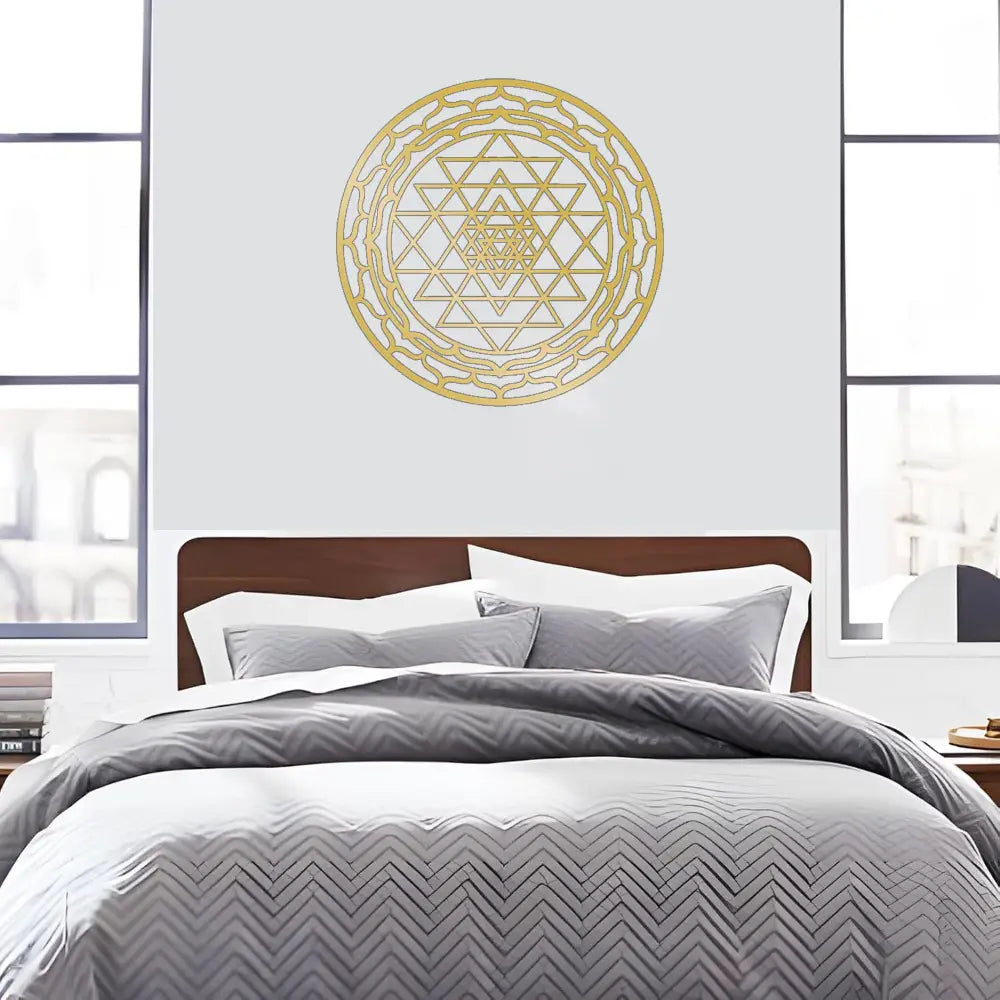 Gold-colored metal wall art featuring an intricate sri yantra sacred geometry design for decorative use.