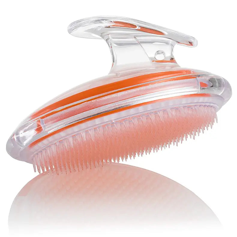 Transparent scalp massage brush with orange accent stripes and soft pink bristles designed as a sleek exfoliating hair meridian comb.