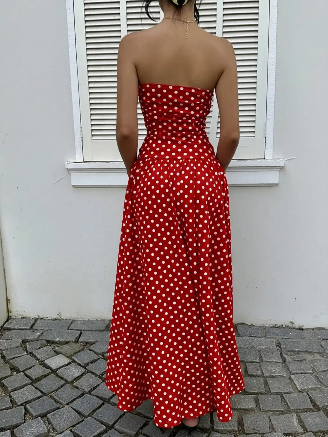 a vibrant red strapless maxi dress with white polka dots made from flowing fabric ideal for elegant occasions