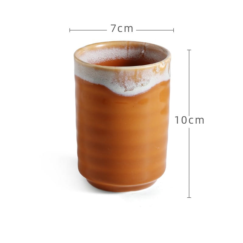 A rustic Japanese ceramic mug with a warm amber glaze and contrasting white textured rim hand-painted for use as a retro 250ml tea cup.