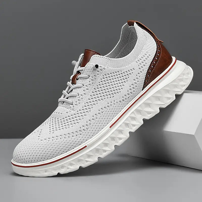 Men’s mesh knit casual lightweight sneaker in white with brown leather accents and a textured white sole.
