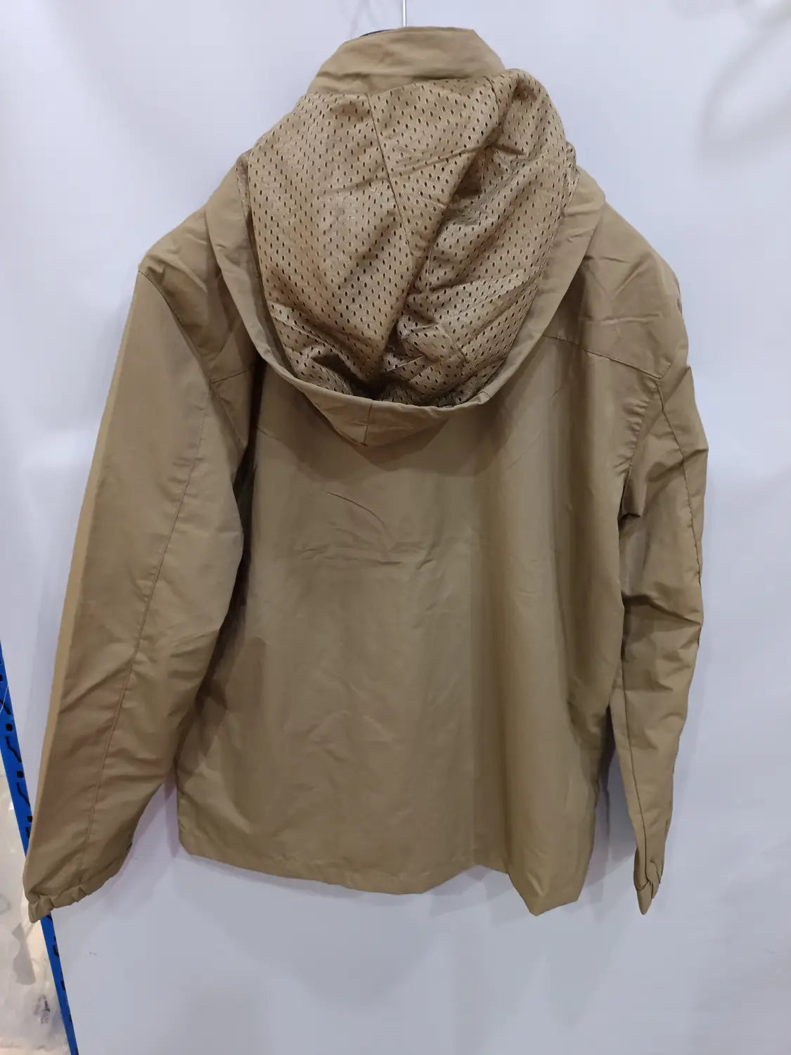Chaqueta de senderismo con capucha impermeable color camel, con un forro de malla perforado en el interior de la capucha