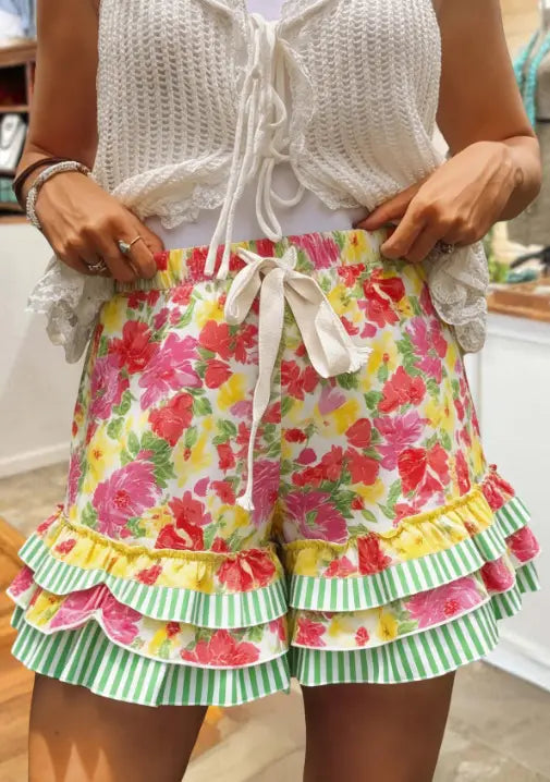Shorts mit floralen Mustern, mit weißem Tunnelzugbund und mehrlagigem, gerafftem Saum in Pink, Gelb, Grün und Weiß, gestylt mit einem Karomosaik-A-Linien-Rock.