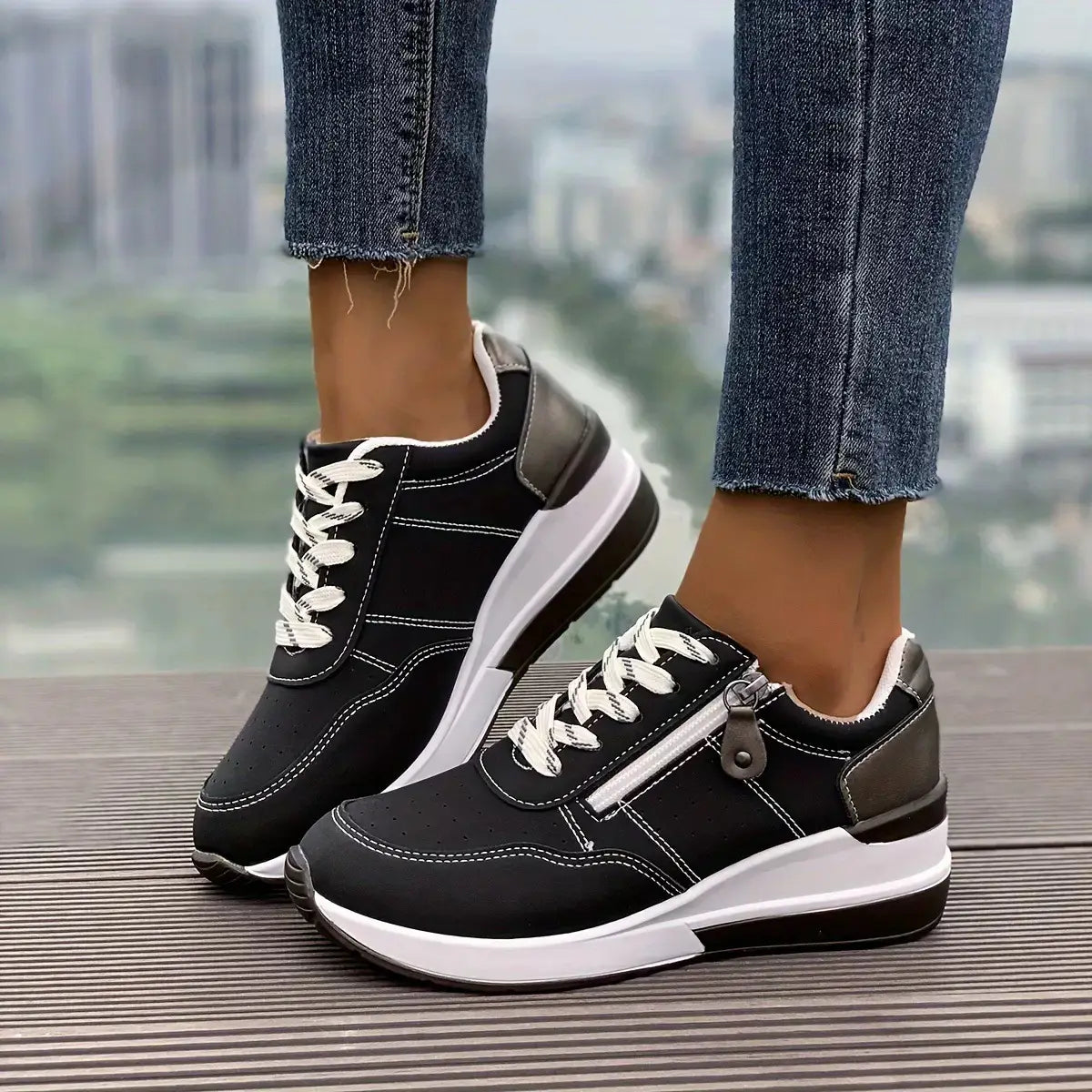 Baskets à plateforme pour femmes en cuir synthétique noir et blanc, au design moderne et épuré, avec des touches grises contrastantes au niveau du talon et de la tirette de fermeture pour un port décontracté.