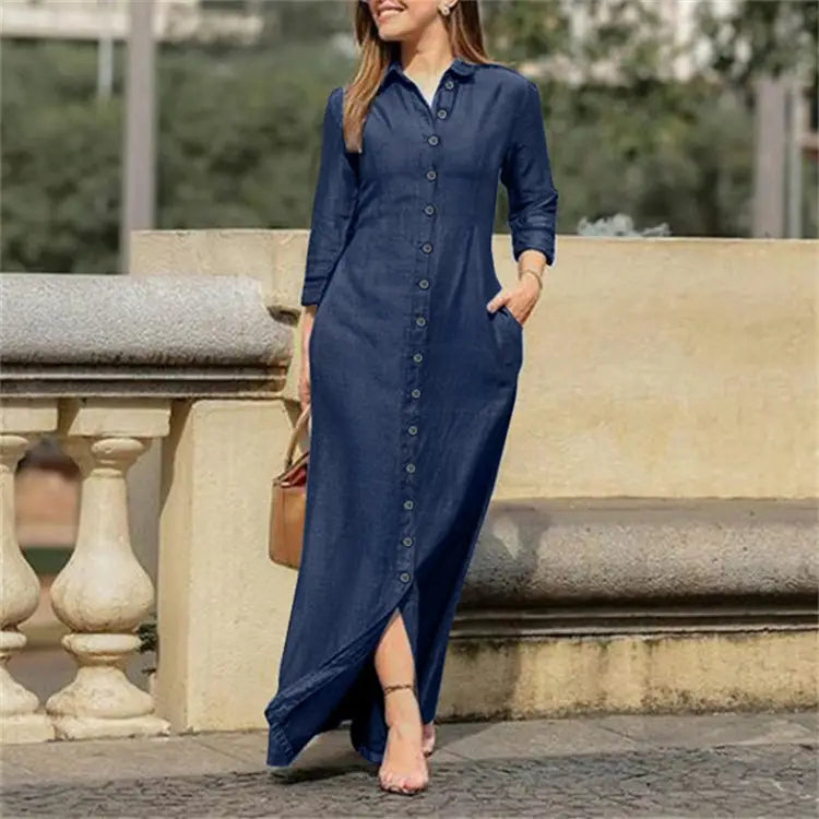 A navy blue denim button front maxi dress with three quarter sleeves and a side slit.