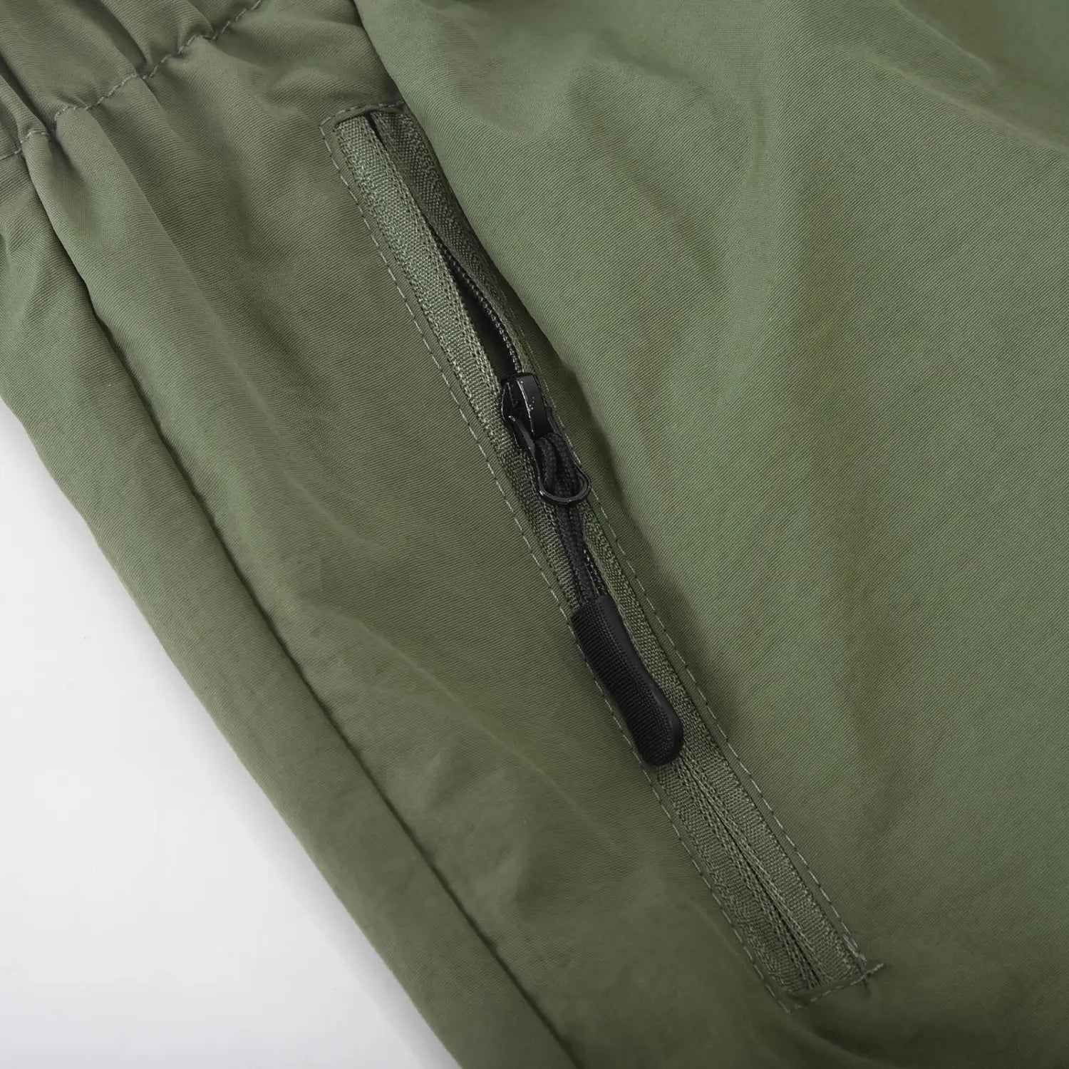 Short cargo athlétique pour hommes en nylon à jambe droite couleur vert olive, avec une poche zippée noire pour un rangement sécurisé.