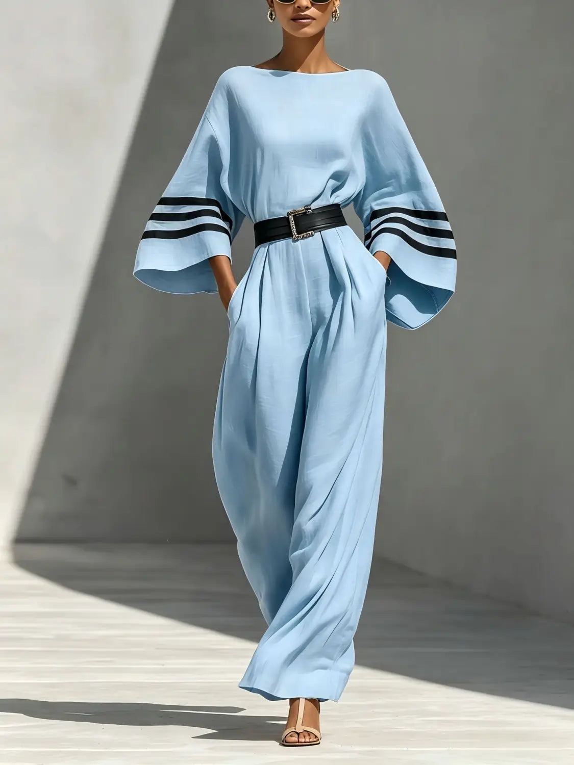 Hellblauer Leinen-Jumpsuit mit weitem Bein, mit schwarzen gestreiften Manschetten und passendem Gürtel.