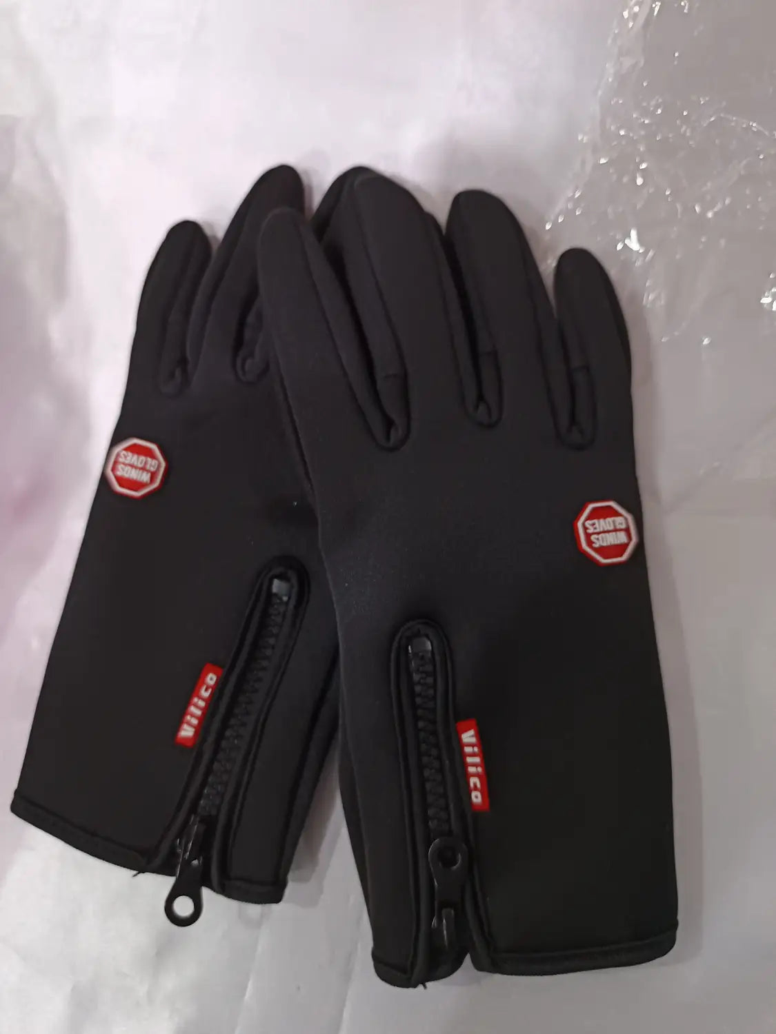 black windproof touchscreen winter gloves with red branding and zipper cuffs shown from the back side for men and women