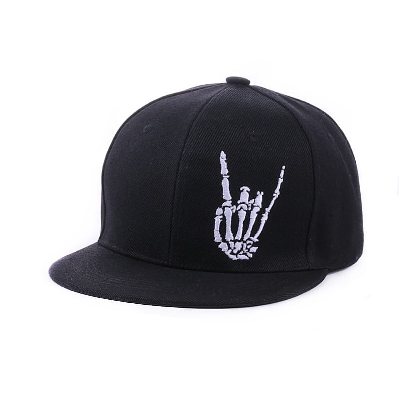 Black snapback baseball cap featuring a white embroidered skeleton hand making the rock on gesture on the front panel.