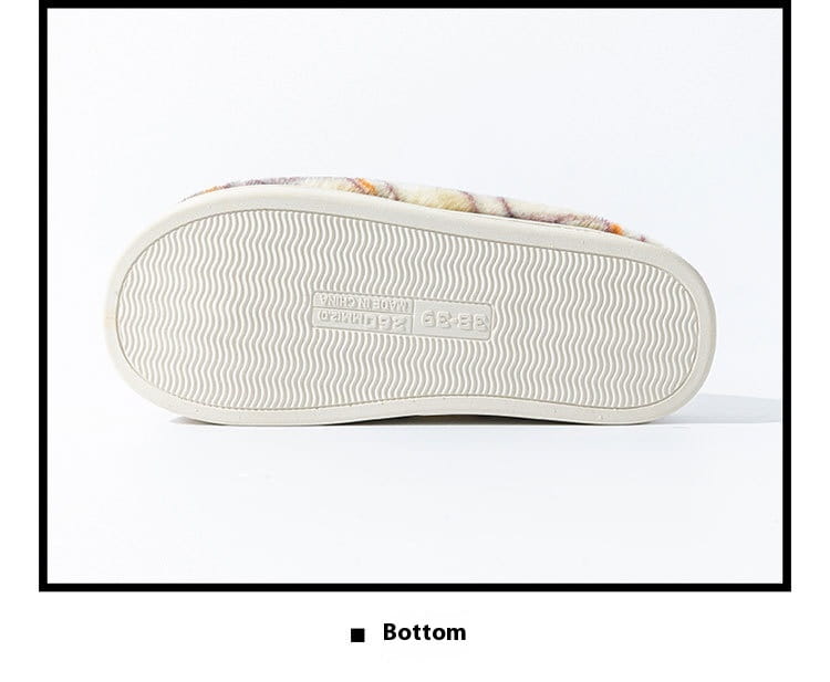 A cozy unisex plaid fleece lined indoor slipper with a soft multicolored patterned upper and a white rubber sole featuring a wavy tread non slip design.