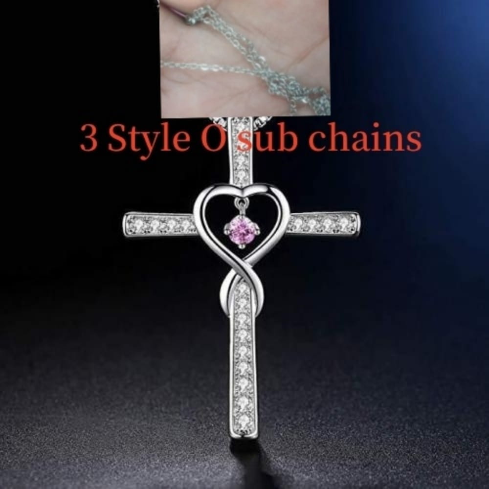 Silver cross pendant necklace featuring a heart-shaped center with a pink birthstone gemstone surrounded by clear crystals and accented with triple style sub chains from the infinity love heart cross birthstone crystal necklace collection.