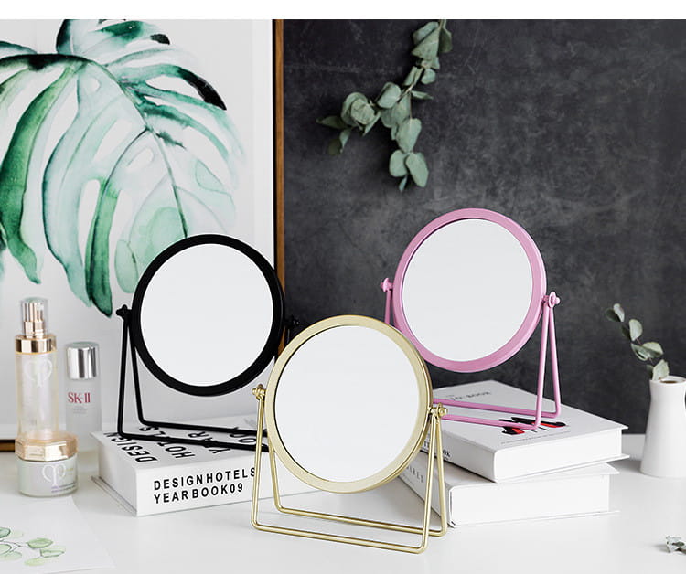 Three round vanity mirrors with slender metal frames in black gold and pink displayed on a white surface for makeup desk use.