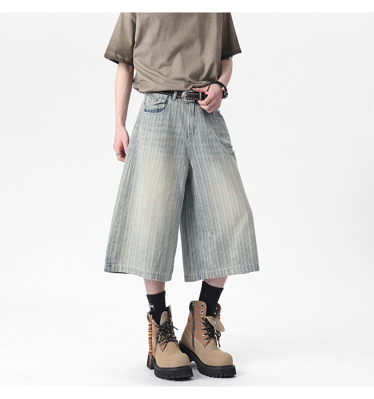 Striped denim capri shorts in a faded light blue wash with subtle vertical stripes and wide-leg design.