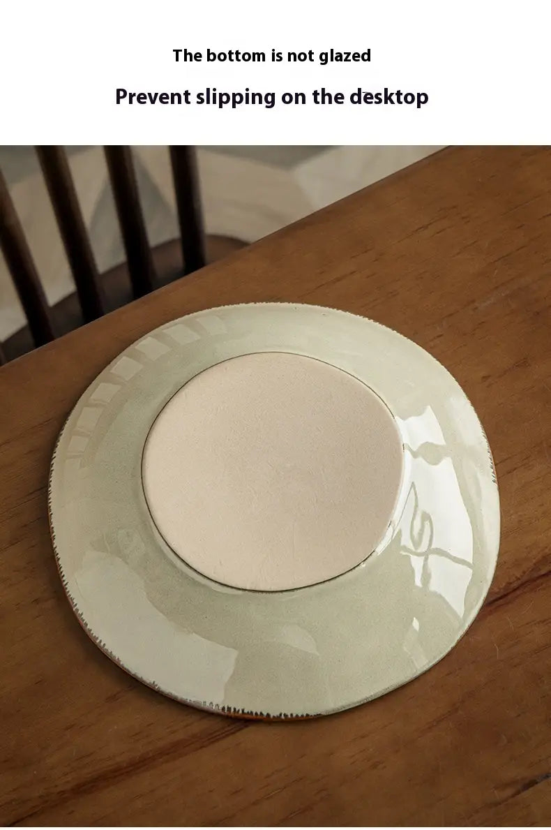 A 9-inch white ceramic deep plate with a blue leaf pattern, subtle gold rim, and textured edge designed for tabletop use.