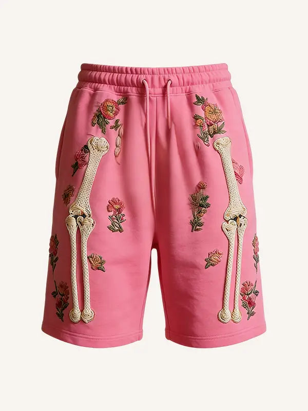 Pink men polyester sweat shorts featuring embroidered floral patterns and cream-colored bone designs