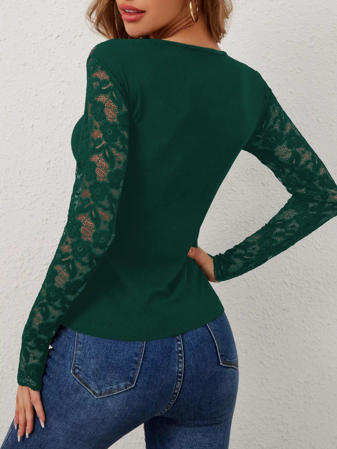 Emerald green butterfly lace back ribbed long sleeve top with intricate lace detailing on the sleeves shown from the back.