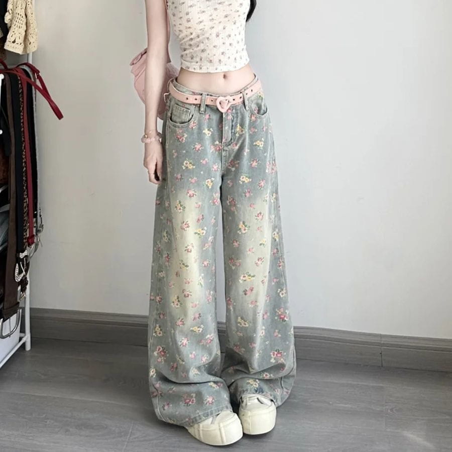 Light blue denim floral high waist wide leg jeans with a faded soft pink and white pattern and a matching pink belt.