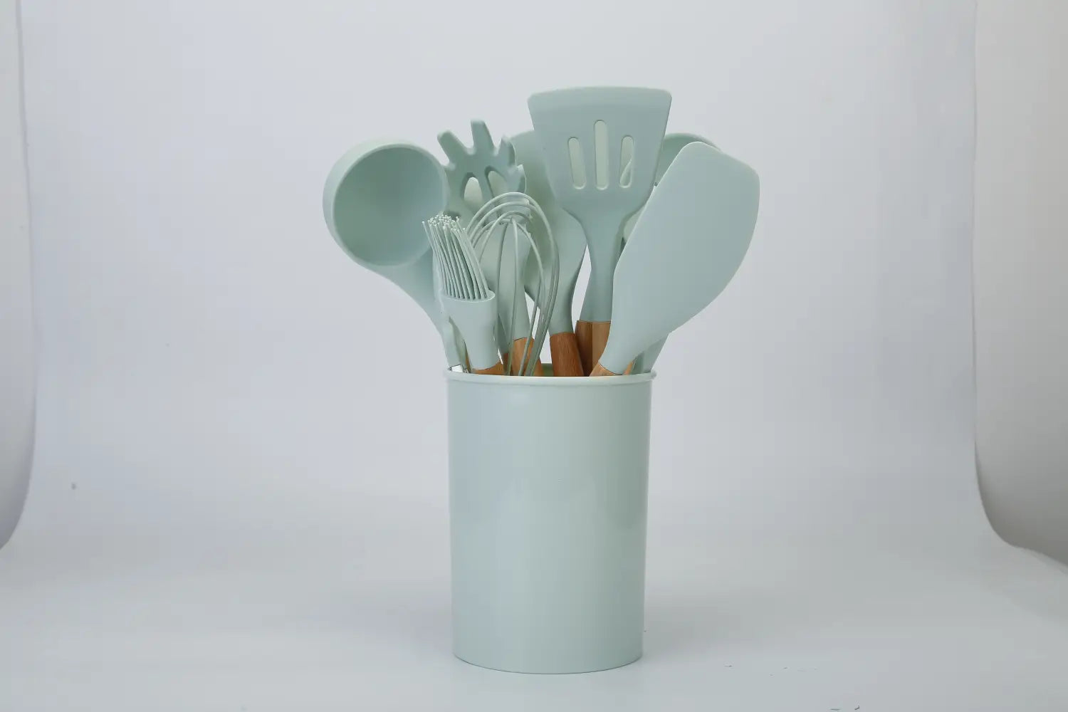 Light blue silicone cooking utensil set with wooden handles in a matching cylindrical container