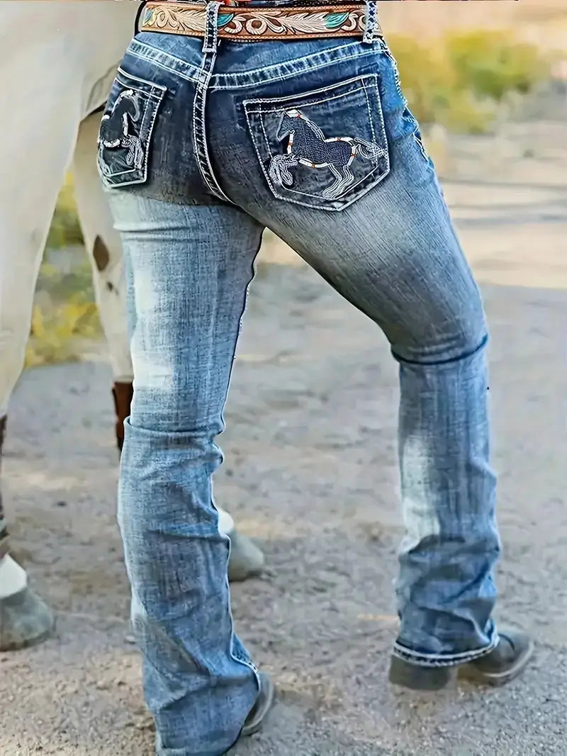 face arrière des jeans droits en denim bleu présentant des motifs de cheval brodés sur les poches arrière et une ceinture florale décorative