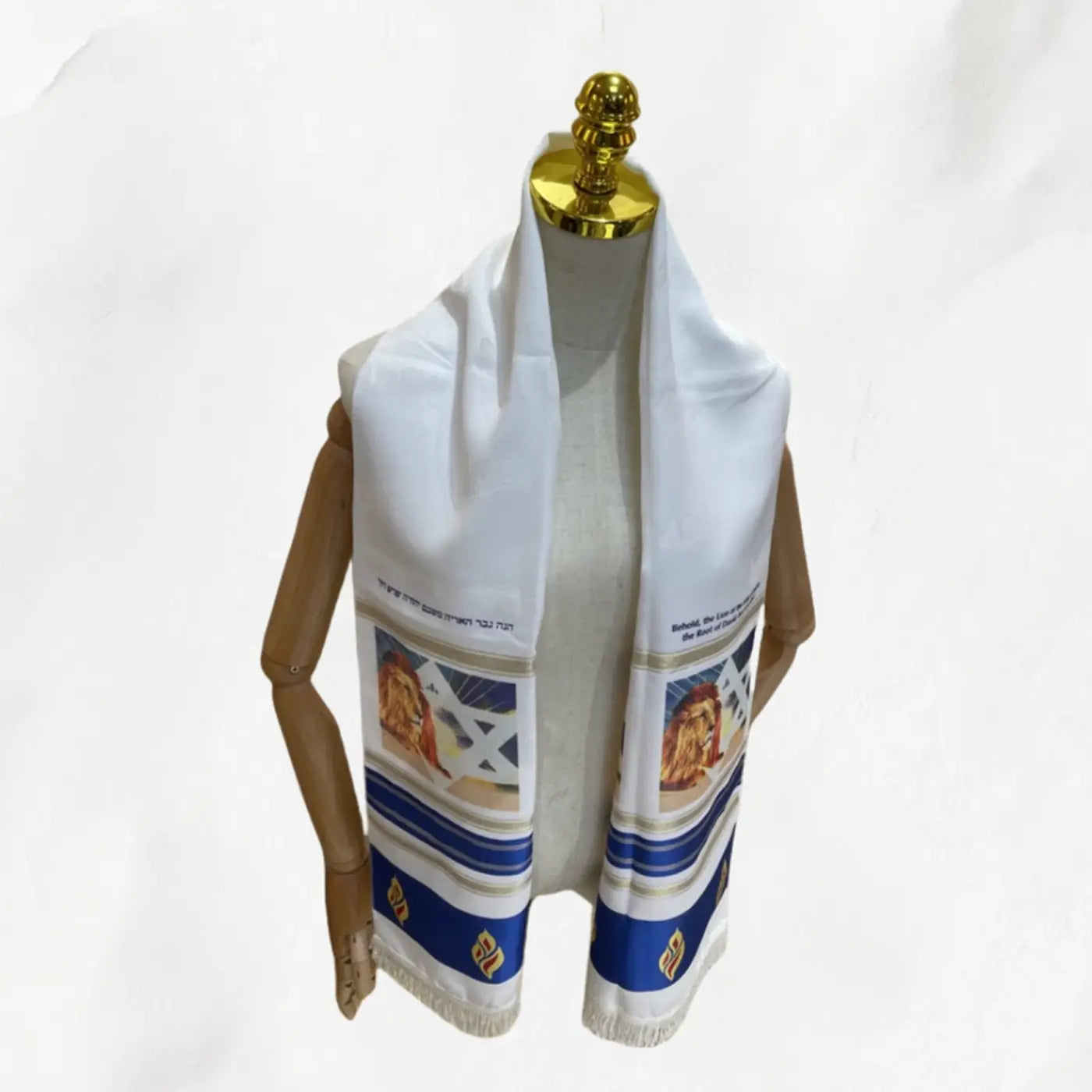 Chal de oración judío pañuelo hebreo blanco con franjas azules y motivos bordados de león expuestos en un maniquí.