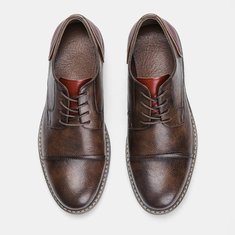 Herren-Lederschnürschuhe mit Kappenzehen im Retro-Business-Casual-Stil in Braun mit kontrastierendem rötlich-braunem Innenfutter und Ziernähten.