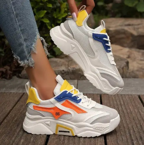 Womens breathable chunky mesh platform sneakers in white and gray with vibrant yellow blue and orange accents on the sides and heel.
