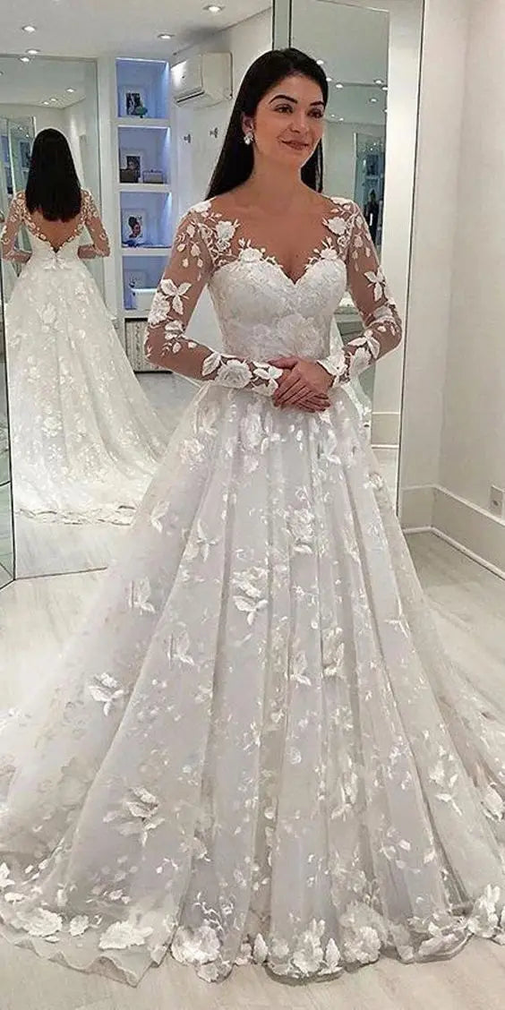 a white lace wedding gown with long sheer sleeves and floral appliqués designed for bridal wear