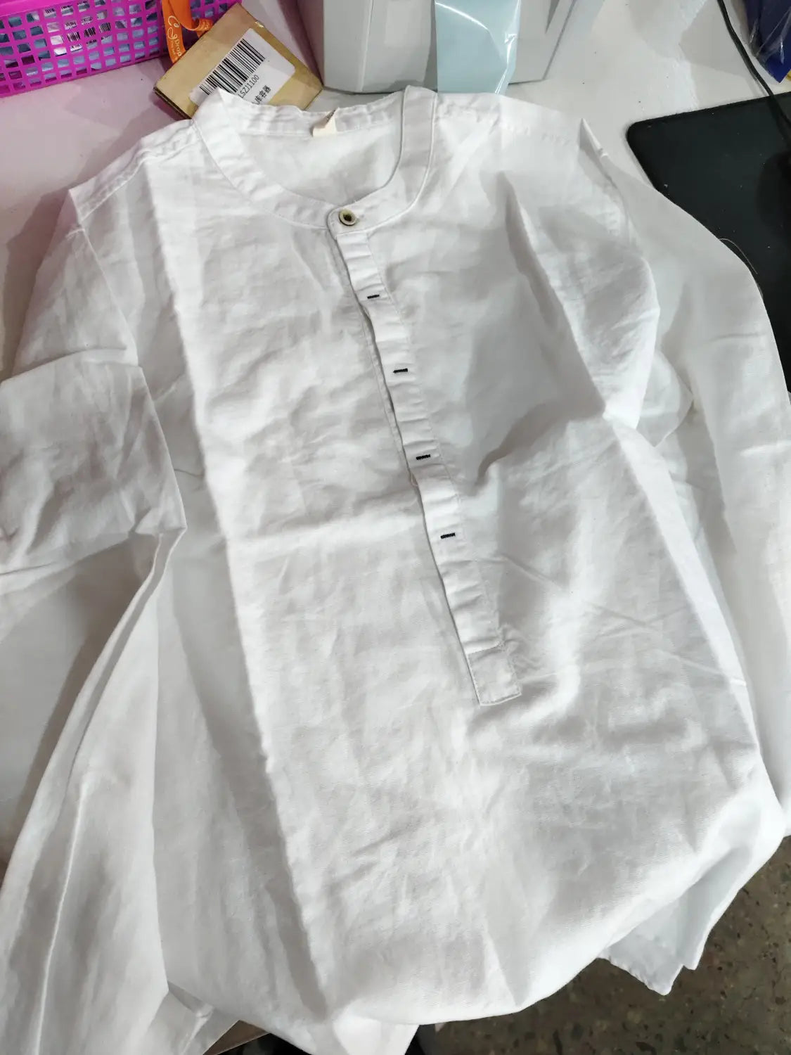 Men’s loose linen white long sleeve shirt with mandarin collar and subtle stitching details.