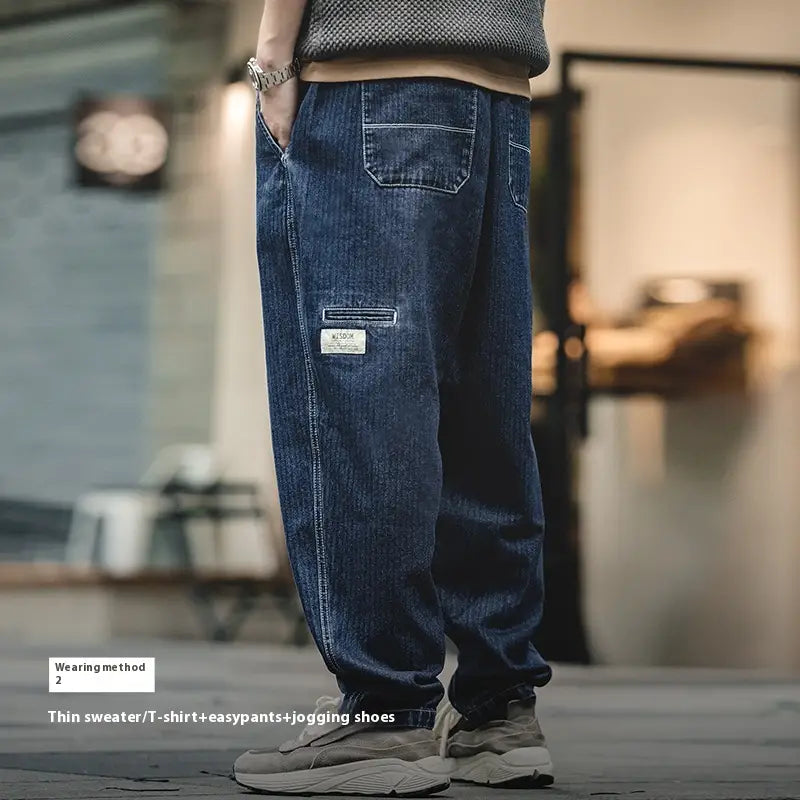 Pantalones vaqueros relajados y cónicos azul marino oscuro para hombre con costuras visibles y un bolsillo con parche en el muslo.