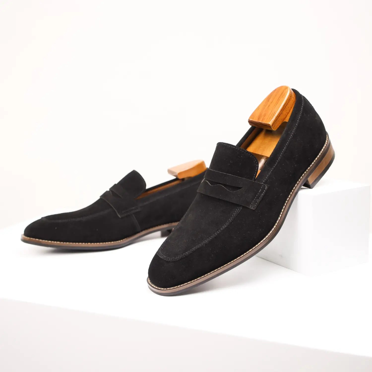 Men’s brown suede penny loafer casual leather shoes featuring a classic slip-on design with black suede and contrasting tan stitching.