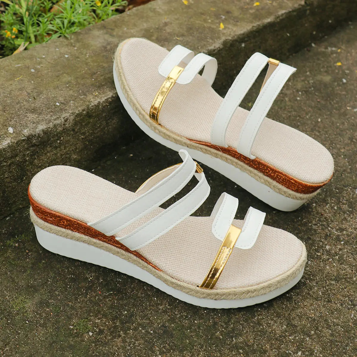 White wedge sandals with espadrille heel featuring gold-tone metal accents and woven rope sole.