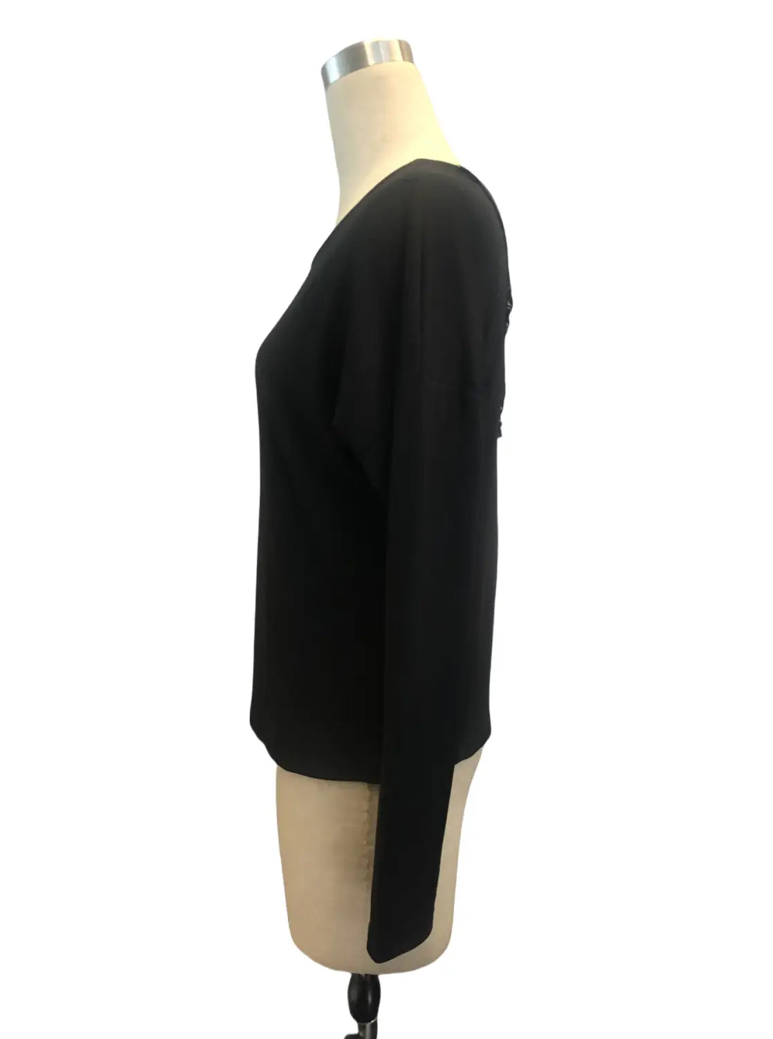 Black butterfly lace back ribbed long sleeve blouse made of lightweight flowing fabric with a subtle side slit shown from the back.