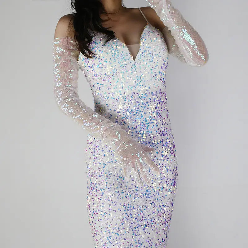 A shimmering white and iridescent sequined bodycon dress paired with long sheer mesh finger gloves in a sequined mesh finger gloves set.