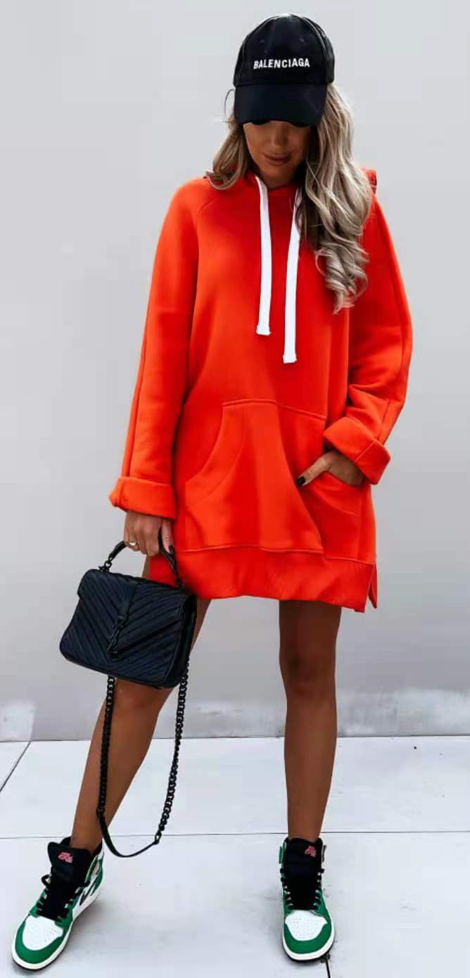 Bright orange oversized mid length hooded sweatshirt dress featuring white drawstrings and side pockets.