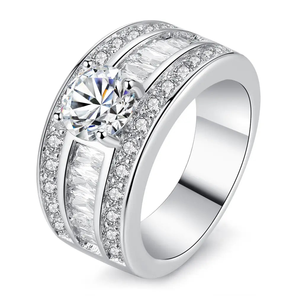 A wide silver-toned adjustable ring featuring a central round-cut diamond with two parallel rows of baguette and pavé-set diamonds vintage zircon heart arrow style.