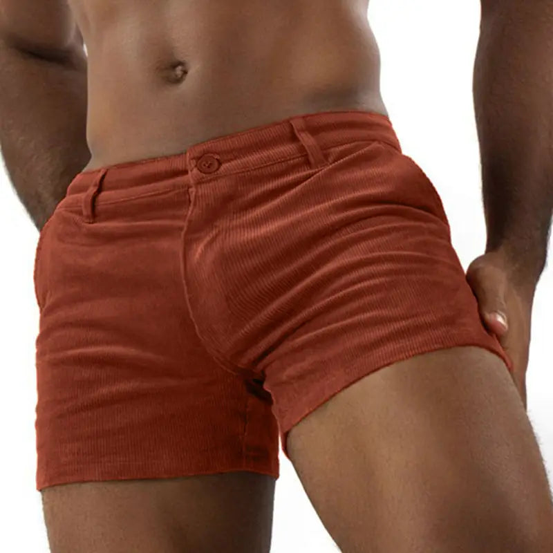 Men corduroy beach shorts in rust orange featuring a classic button closure and belt loops for casual mid rise wear.