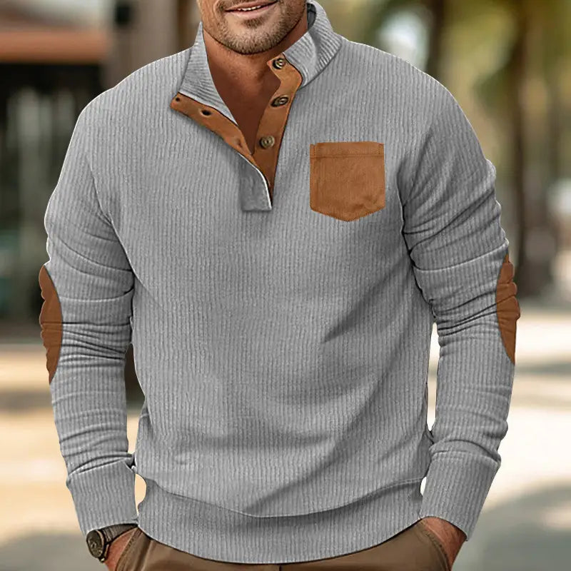 Slim fit corduroy patchwork pullover in gray ribbed knit with brown leather accents on the collar placket buttons chest pocket and elbow patches.