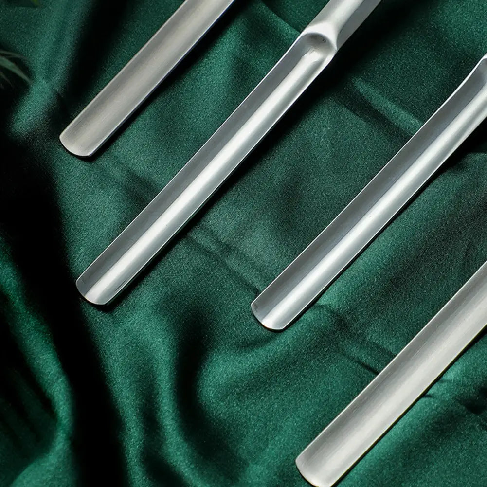 cinq arbres à chaussures argentés élégants en acier inoxydable, avec une finition polie, disposés en diagonale sur une surface en tissu vert foncé, dans le cadre du produit de fourchette-slicer à pastèque en acier inoxydable coupeur 2-en-1.