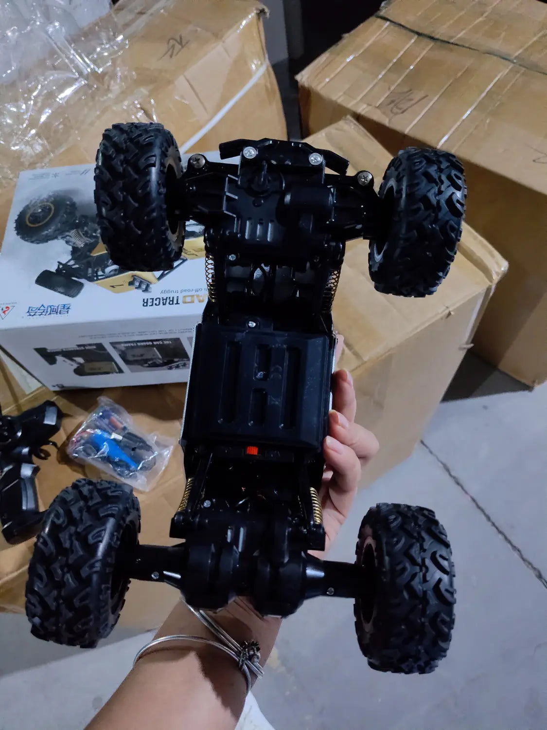 Camion teledirigido RC todoterreno 4WD de alta velocidad en negro, con neumáticos resistentes de dibujo pronunciado y un chasis detallado.