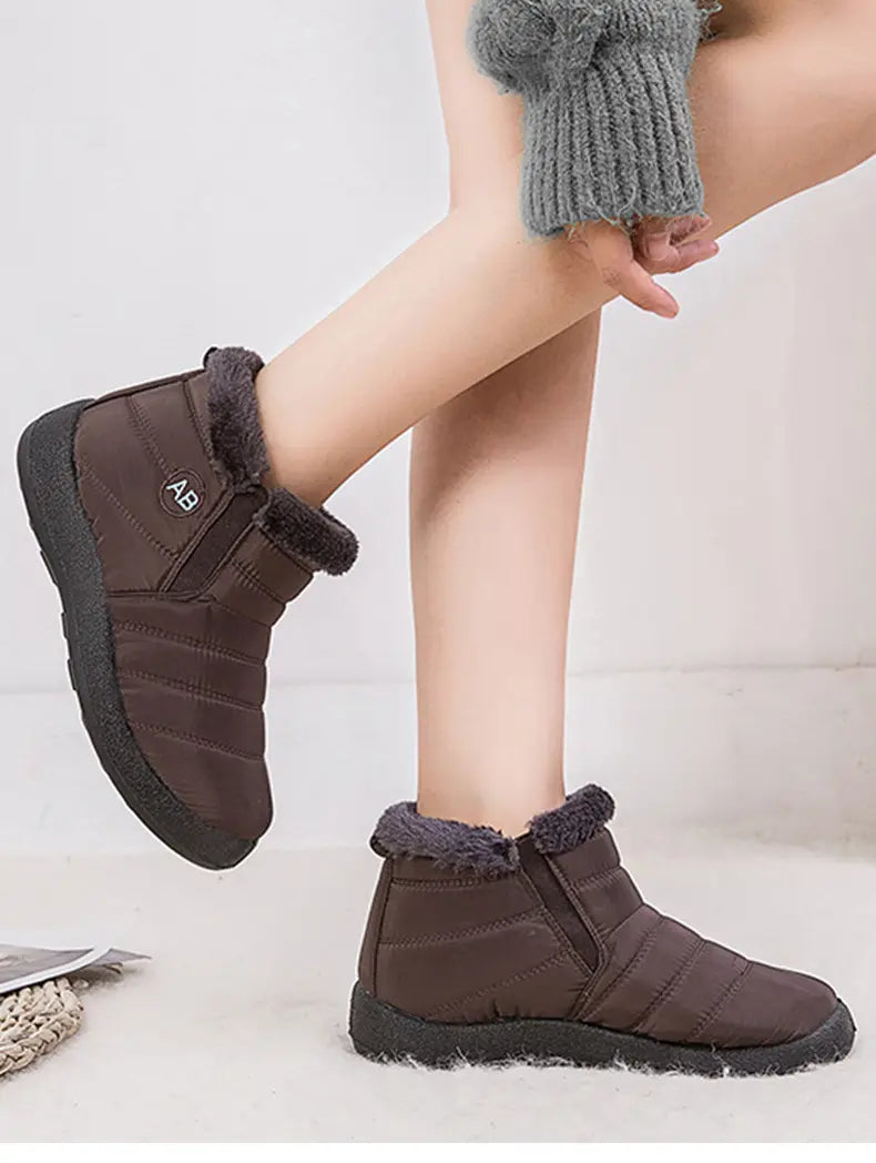 Botte d’hiver imperméable en neige brune matelassée, avec doublure intérieure moelleuse en fausse fourrure grise et semelle en caoutchouc noir, conçue pour les conditions froides.