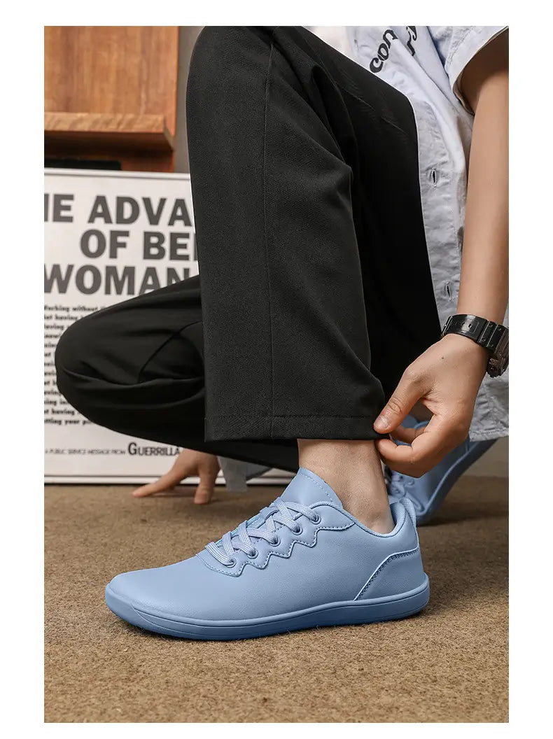 Hellblaue Leder-Outdoor-Sneaker mit glatter, matter Oberfläche und dezentem wellenförmigem Ziernähte-Verlauf entlang der Vorderkappe, entworfen für minimalistische Freizeitschuhe.
