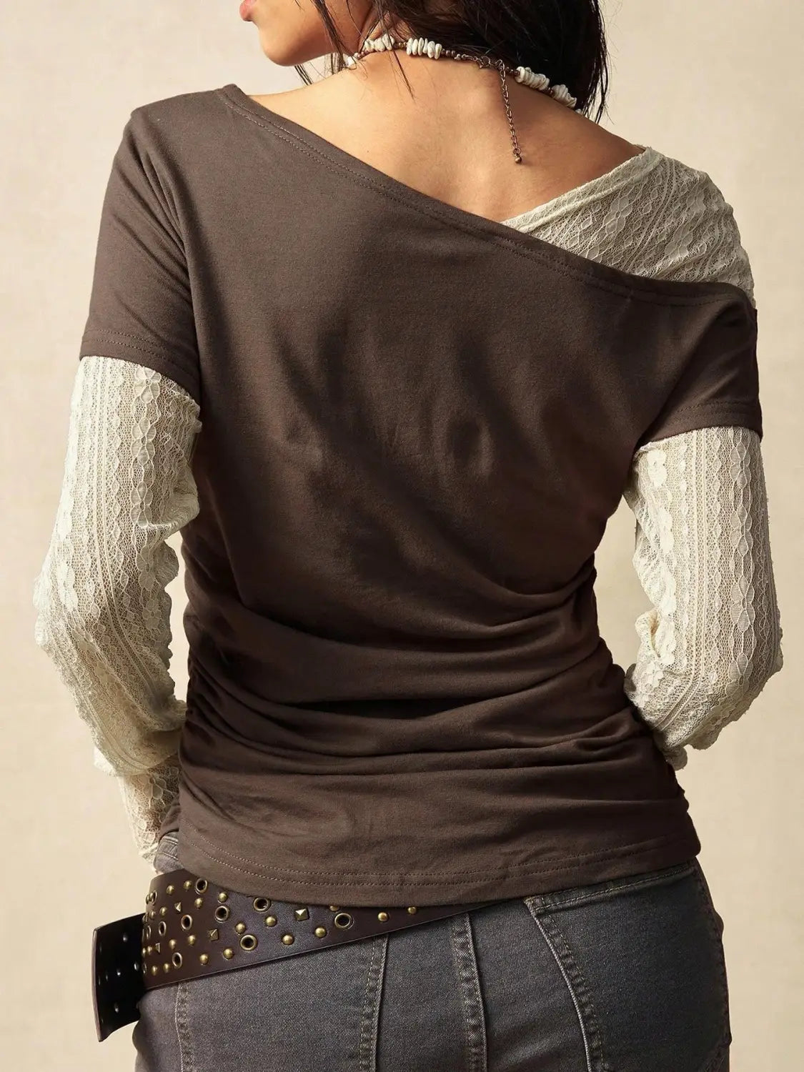 A dark brown lace layer off shoulder knitted top featuring sheer lace sleeves and a relaxed fit.