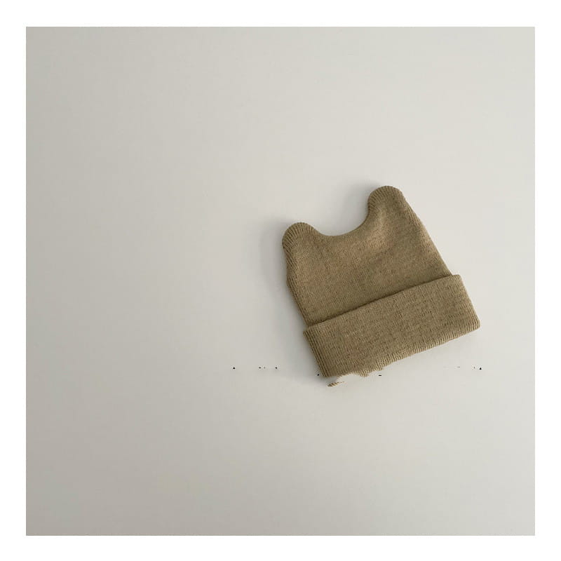 Children’s knitted beanie hat in soft beige with a folded cuff and rounded textured crown designed as a warm winter cap.