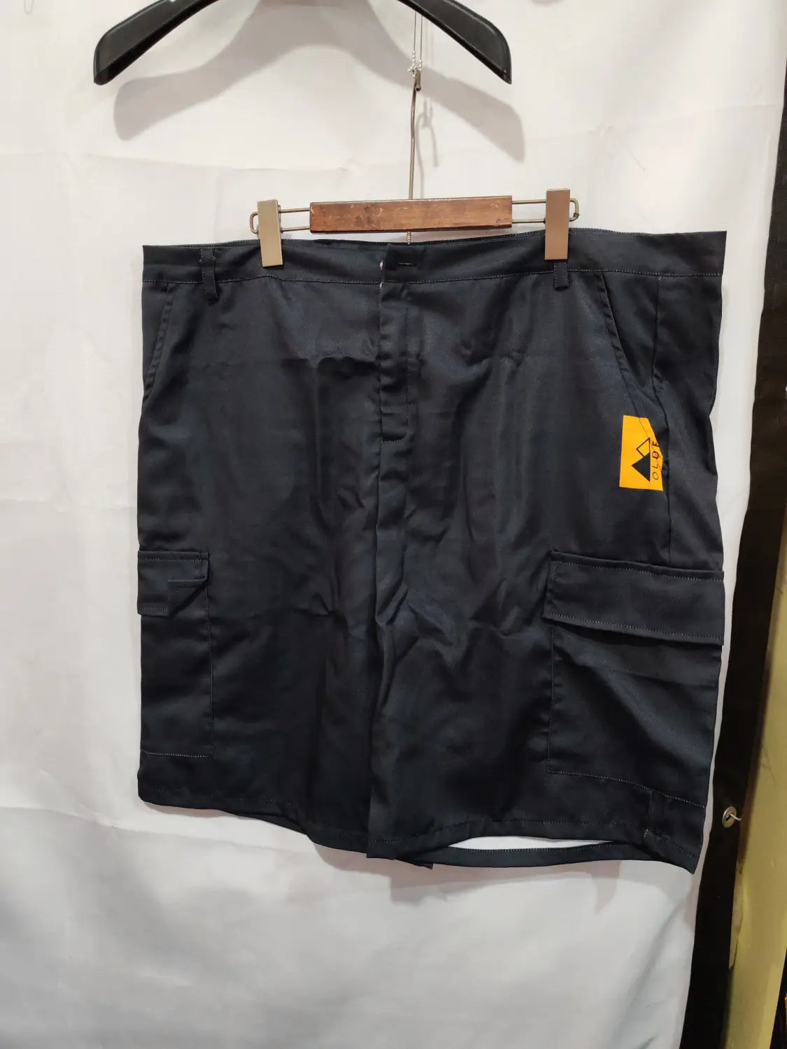 Men’s digital print cargo shorts in black polyester featuring multiple pockets and a yellow brand tag on the side.